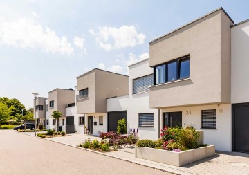 Eine Wohnsiedlung mit modernen Häusern, die durch eine energieeffiziente Bauweise bestechen. © Westend61 / Westend61 via Getty Images (ID: 1032839202)